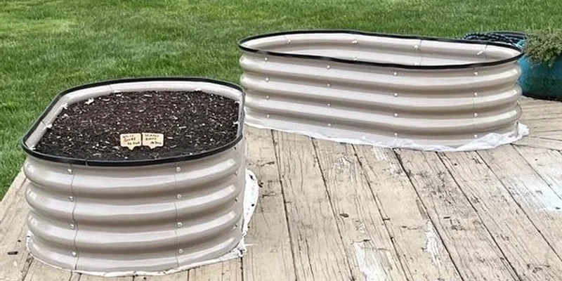 Two light-coloured corrugated metal raised garden beds with rounded ends